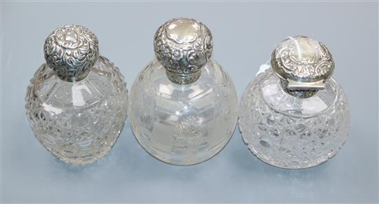 Three late Victorian and later repousse silver mounted cut scent bottles including Mappin & Webb London, 1896, tallest 14.3cm.